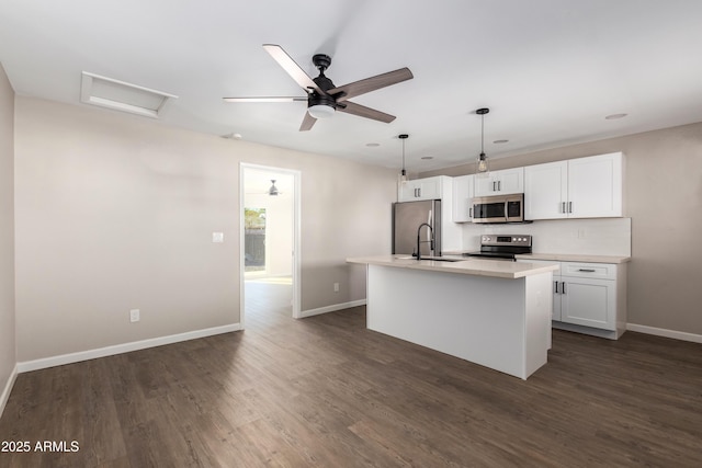 kitchen with sink, dark hardwood / wood-style floors, a center island with sink, white cabinets, and appliances with stainless steel finishes