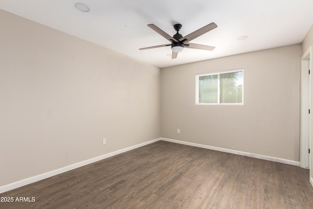 spare room featuring ceiling fan and dark wood-type flooring