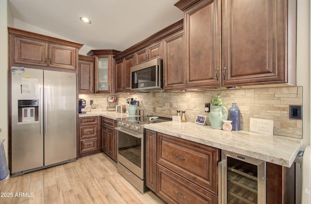 12041 S 45th St, Phoenix, AZ 85044 - kitchen with light stone countertops, light wood-type flooring, appliances with stainless steel finishes, wine cooler, and decorative backsplash