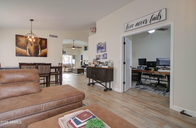 12041 S 45th St, Phoenix, AZ 85044 - living room featuring visible vents, baseboards, arched walkways, light wood finished floors, and ceiling fan with notable chandelier