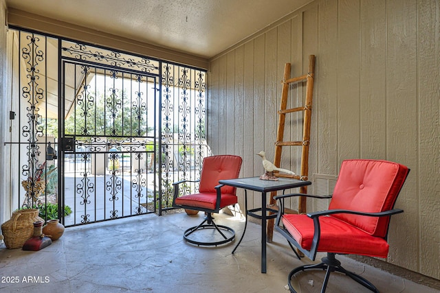 sitting room with wood walls and concrete floors