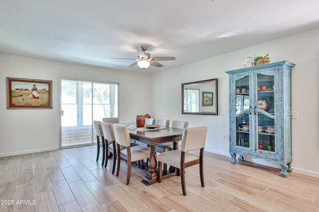 dining space with wood tiled floor, ceiling fan, and baseboards