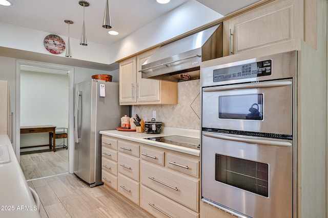 kitchen featuring decorative backsplash, stainless steel appliances, light countertops, wall chimney range hood, and light brown cabinets