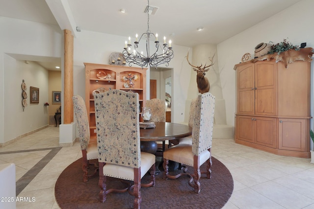 dining space with decorative columns, light tile patterned floors, and a chandelier