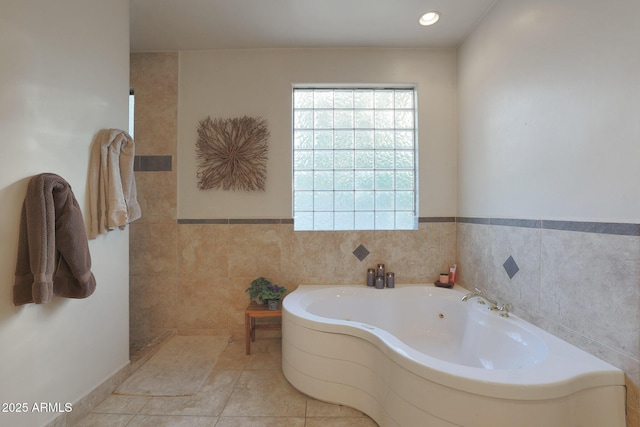 bathroom featuring tile patterned flooring, tile walls, and a tub