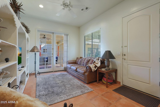 tiled living room featuring ceiling fan and french doors