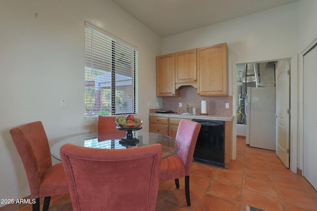 kitchen with light brown cabinets, black dishwasher, white refrigerator, backsplash, and light tile patterned floors