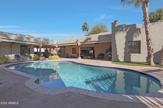 view of swimming pool with ceiling fan and a patio area