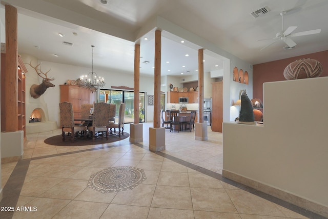 interior space featuring light tile patterned flooring and ceiling fan with notable chandelier