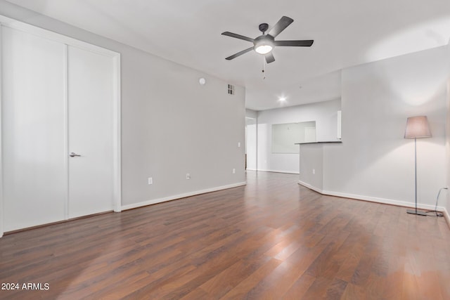 unfurnished living room with ceiling fan and dark wood-type flooring