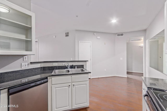 kitchen with white cabinetry, sink, stainless steel dishwasher, dark stone countertops, and wood-type flooring