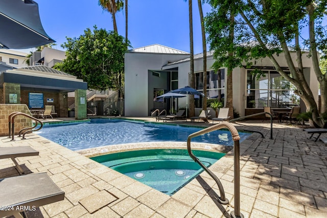 view of swimming pool featuring a community hot tub and a patio