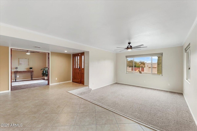 spare room featuring baseboards, light tile patterned flooring, crown molding, and light colored carpet