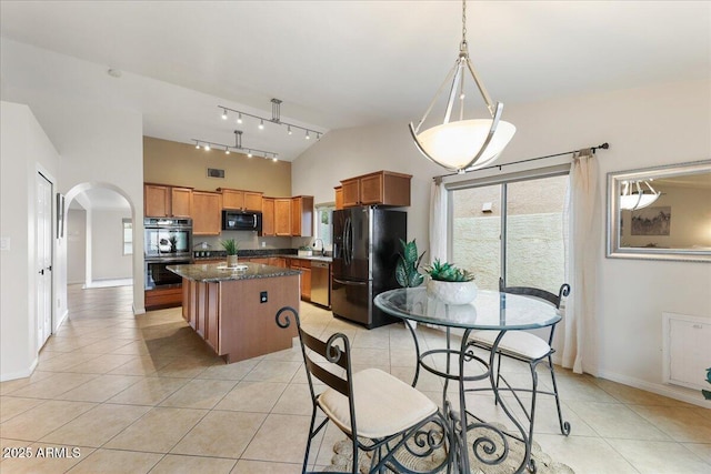 2923 N 63rd St, Mesa, AZ 85215 - kitchen featuring arched walkways, a kitchen island, black appliances, and light tile patterned floors