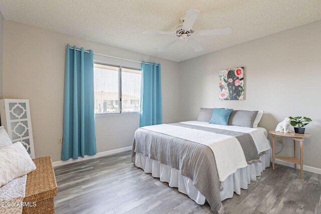 bedroom with hardwood / wood-style flooring, ceiling fan, and a textured ceiling