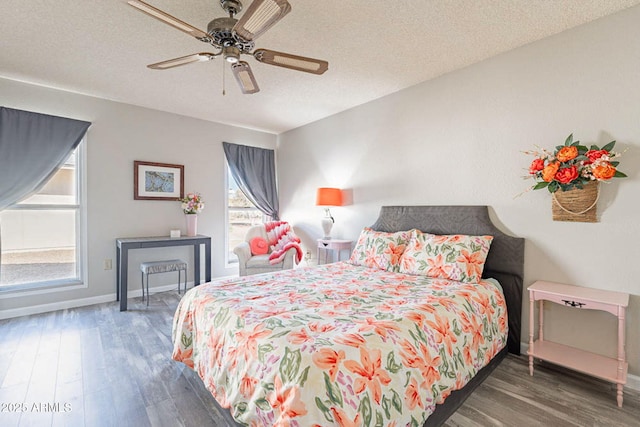 bedroom with ceiling fan, dark wood-type flooring, and a textured ceiling