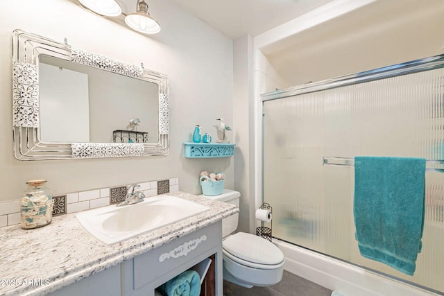 bathroom featuring vanity, toilet, and an enclosed shower