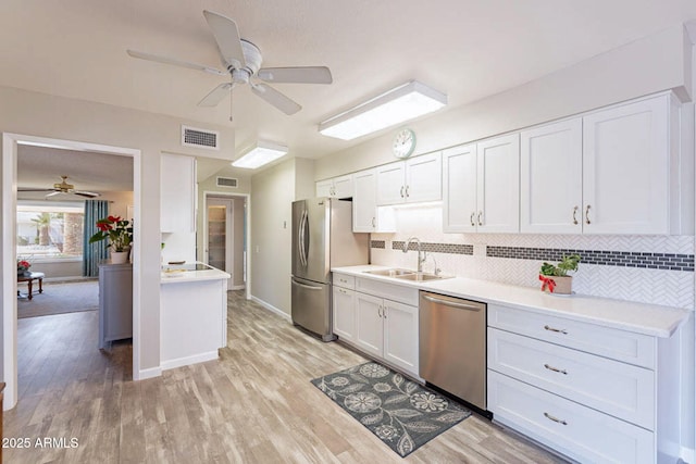 kitchen featuring white cabinetry, sink, light wood-type flooring, and appliances with stainless steel finishes