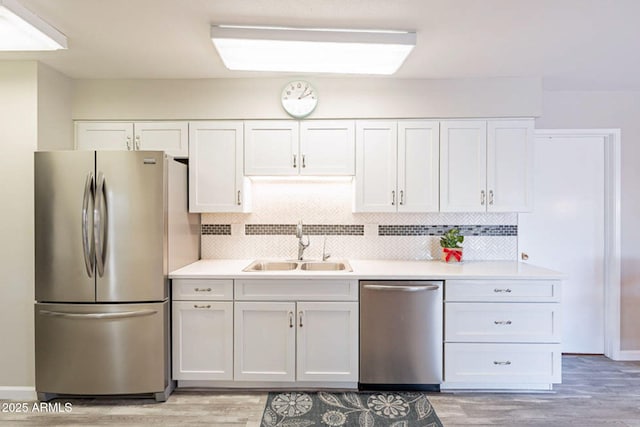 kitchen featuring white cabinetry, sink, backsplash, and appliances with stainless steel finishes