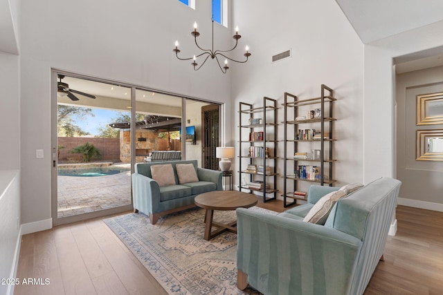 interior space featuring visible vents, baseboards, a notable chandelier, and wood finished floors