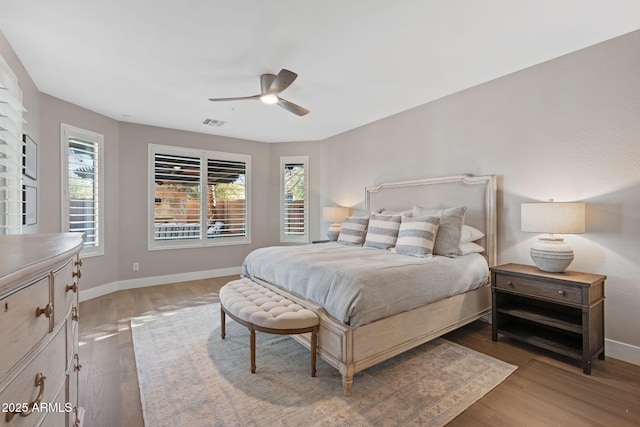 bedroom with multiple windows, visible vents, and baseboards