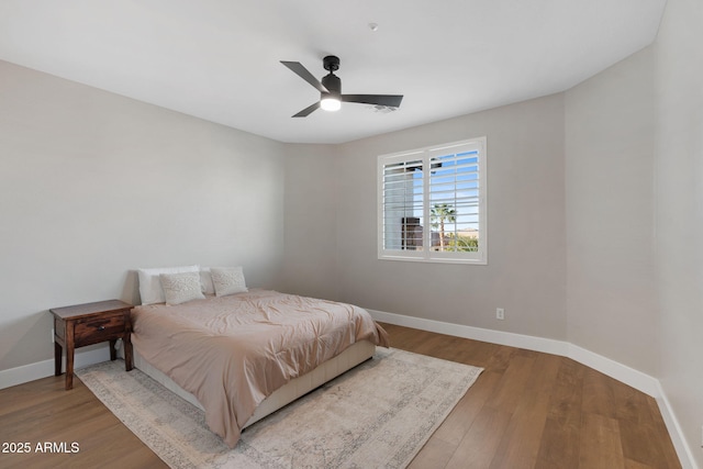 bedroom featuring a ceiling fan, baseboards, and wood finished floors