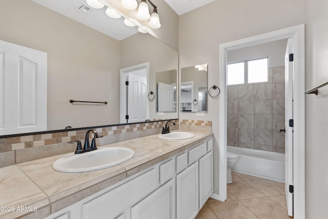 bathroom with toilet, tasteful backsplash, visible vents, and a sink