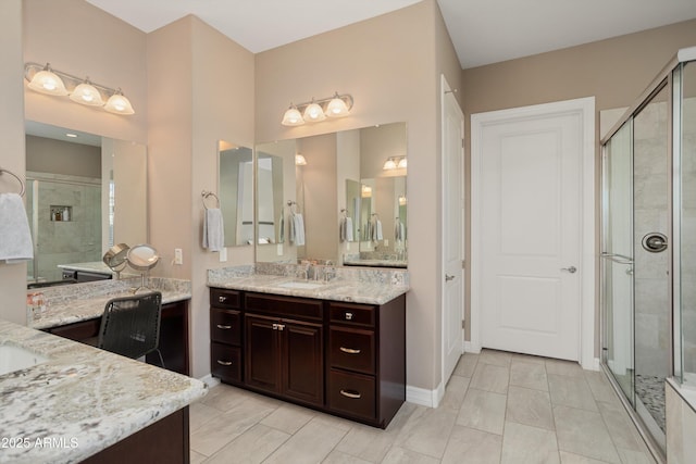 bathroom with vanity, a shower stall, and baseboards