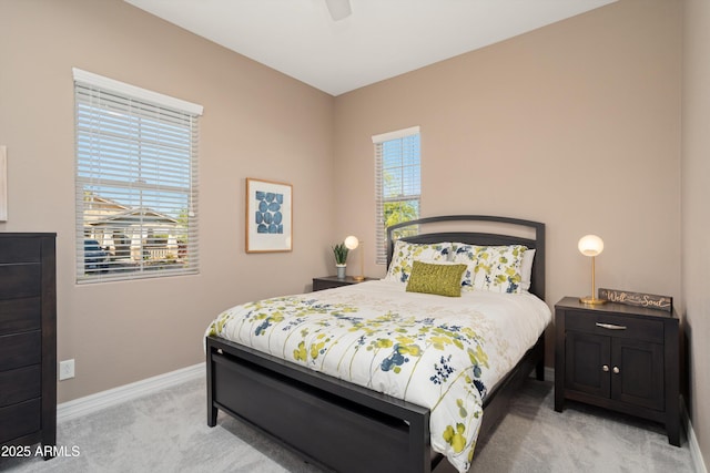 bedroom featuring ceiling fan, light colored carpet, and baseboards
