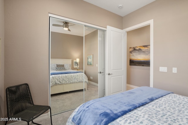 carpeted bedroom featuring baseboards and a closet