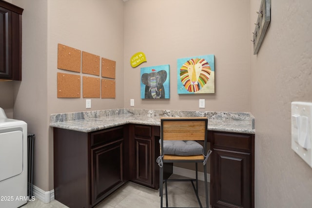 washroom with cabinet space, washer / dryer, and baseboards