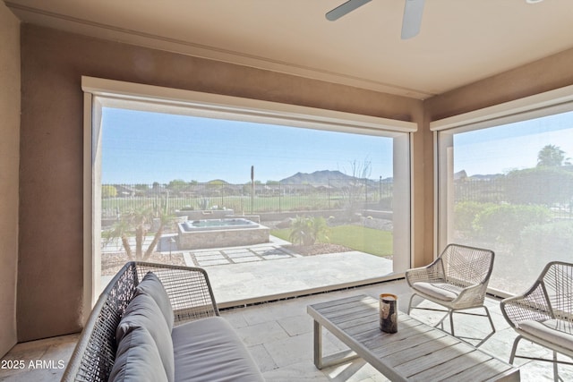 sunroom featuring a mountain view and a hot tub