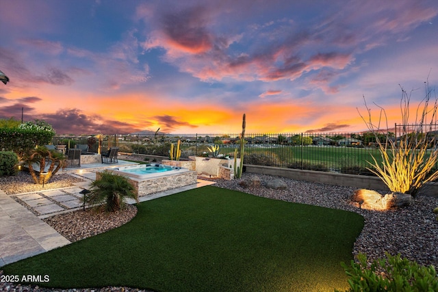 yard at dusk with a patio and a fenced backyard