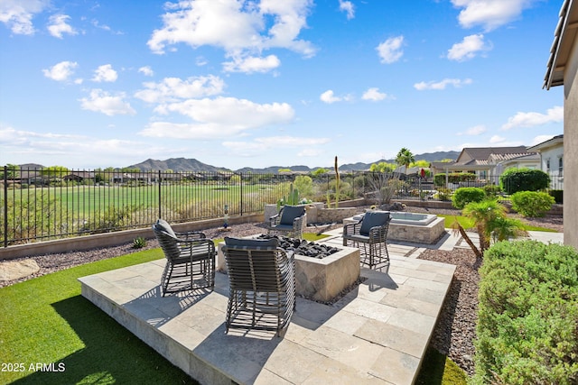 view of patio / terrace with an outdoor living space with a fire pit, a mountain view, and a fenced backyard