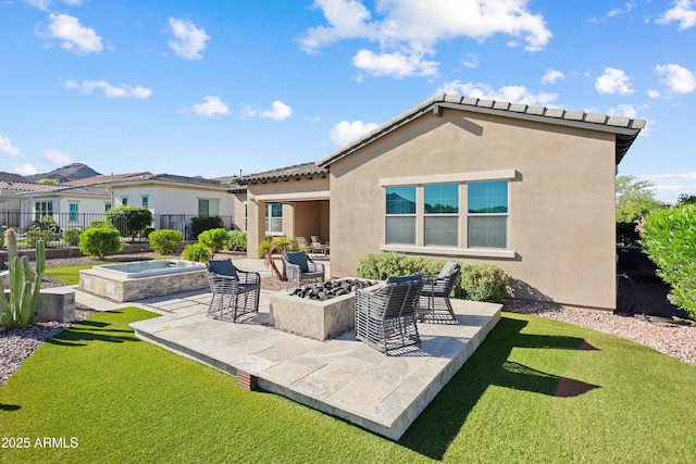back of house with stucco siding, a fire pit, a patio area, and a yard