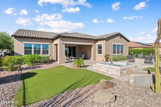 rear view of property with a patio, a yard, an in ground hot tub, a tiled roof, and stucco siding