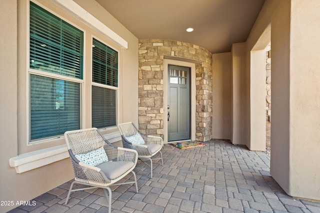 entrance to property featuring stucco siding and stone siding