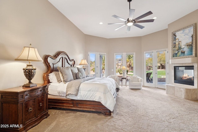 bedroom with carpet floors, recessed lighting, a tiled fireplace, a ceiling fan, and access to outside