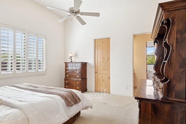 bedroom with carpet floors, a towering ceiling, and a ceiling fan