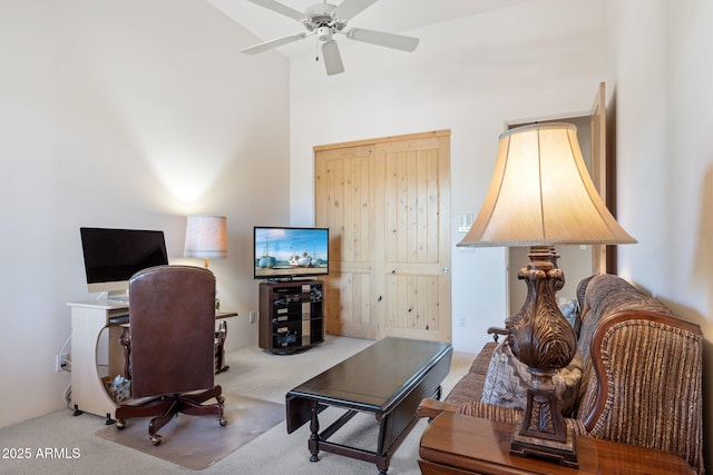 carpeted home office with a high ceiling and a ceiling fan