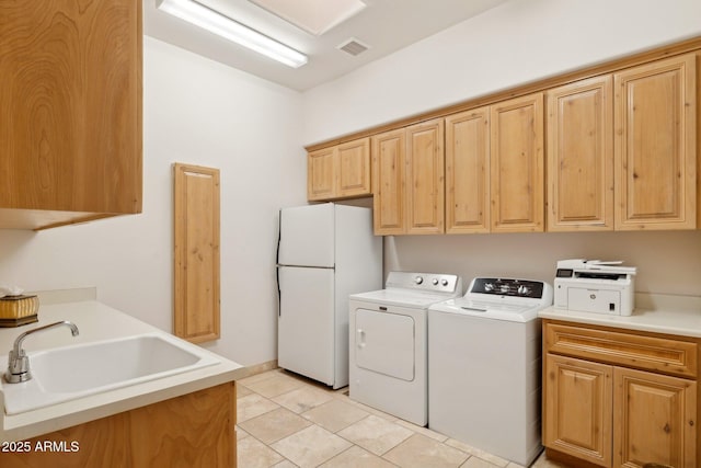 washroom with light tile patterned flooring, washing machine and dryer, a sink, visible vents, and cabinet space