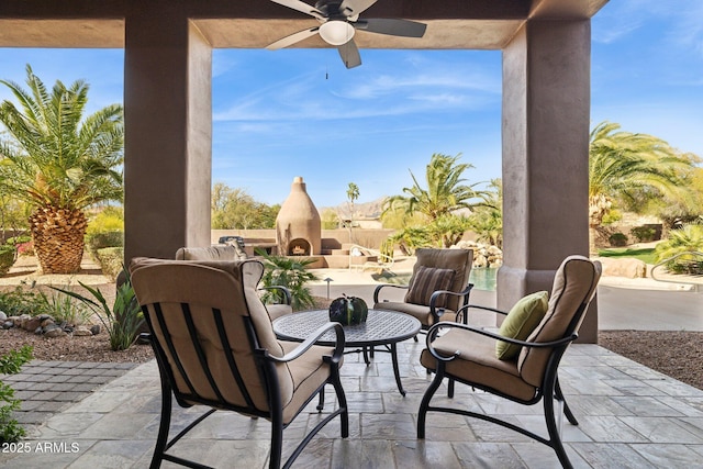 view of patio / terrace with an outdoor living space with a fireplace and ceiling fan