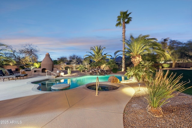 pool featuring a patio, an outdoor fireplace, and an in ground hot tub