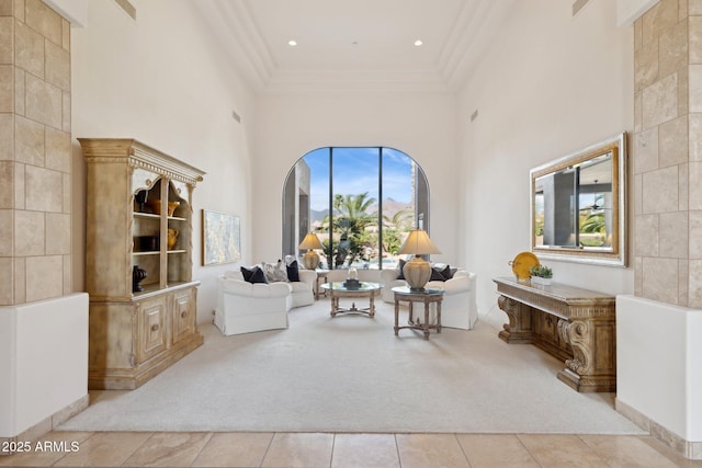 living room with light carpet, crown molding, a high ceiling, and light tile patterned floors