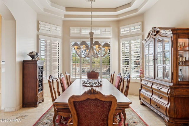 dining area featuring arched walkways, a notable chandelier, visible vents, a towering ceiling, and a raised ceiling