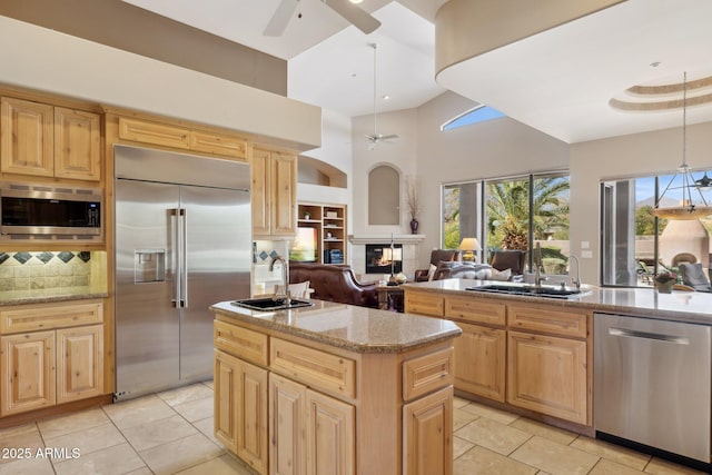 kitchen featuring light brown cabinetry, a sink, and built in appliances