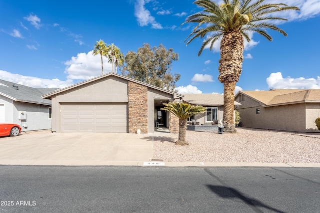 view of front of home featuring an attached garage, stone siding, concrete driveway, and stucco siding