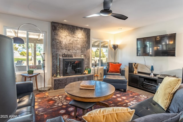 living room featuring a fireplace, wood-type flooring, and ceiling fan