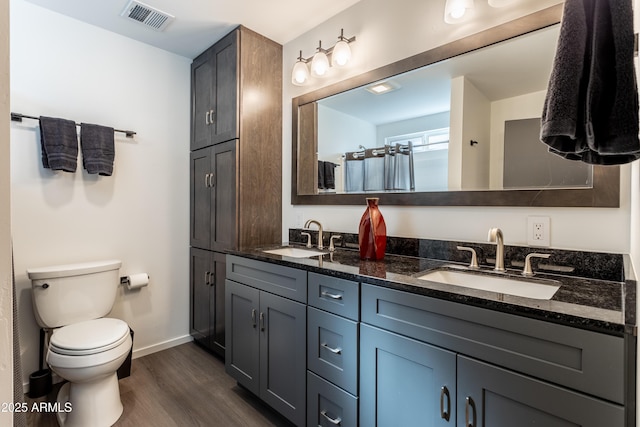 full bathroom featuring visible vents, a sink, toilet, and wood finished floors