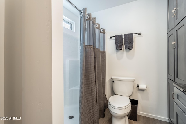 full bath featuring baseboards, wood finished floors, toilet, and a shower with curtain